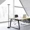 Un bureau moderne avec une grande fenêtre montre un bureau sur lequel se trouvent un ordinateur portable, une tasse et une chaise. Une lampe sur pied est placée à gauche de l'image.