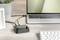 Un ordinateur portable est connecté à un petit hub noir par un câble USB, qui se trouve sur une table à côté d'un clavier.