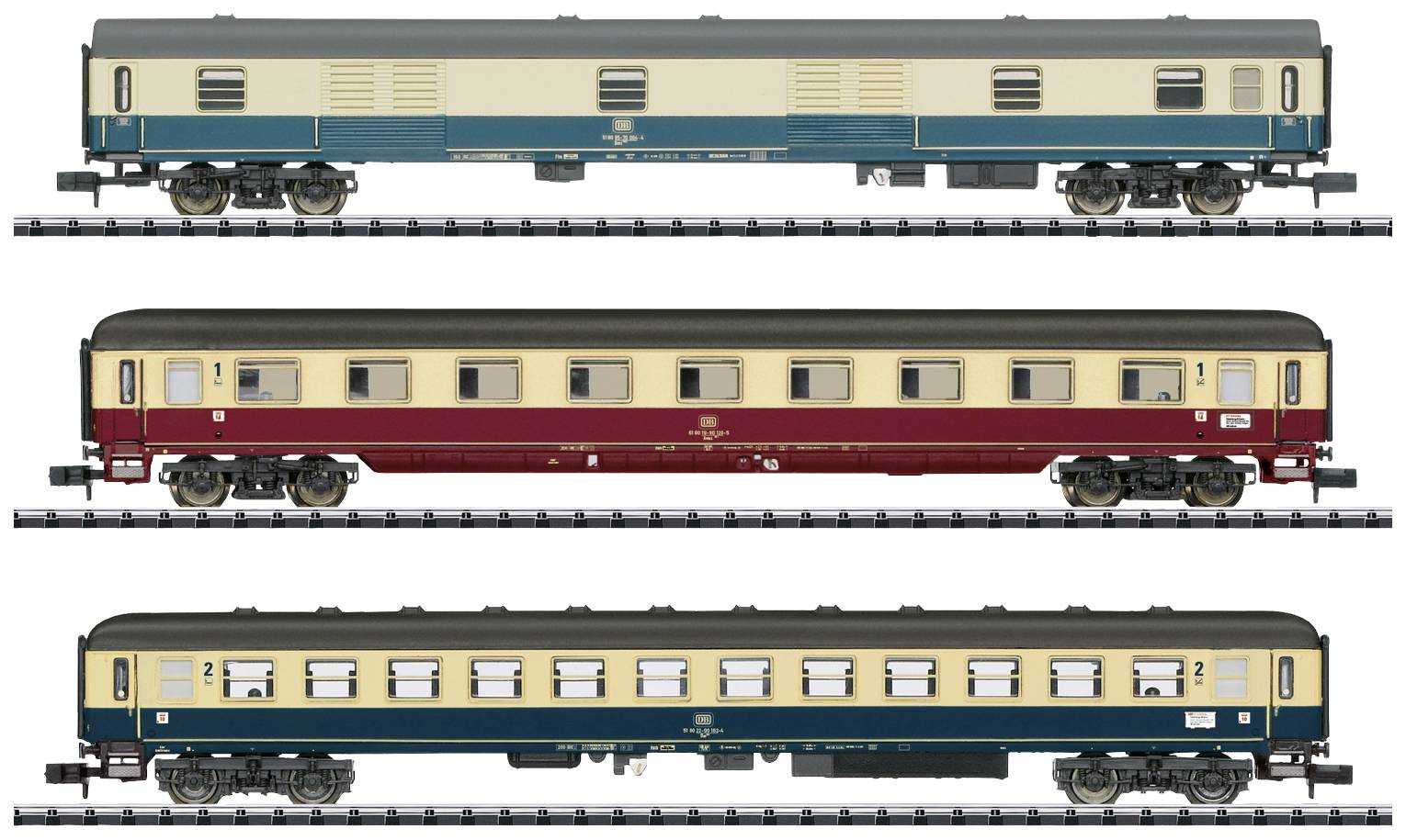Trois voitures de voyageurs de train miniature de différentes couleurs et designs, placées côte à côte sur des rails.