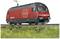 Train rouge des CFF avec pantographe sur les rails, photographié de côté. Premier plan herbeux, ciel bleu en arrière-plan.