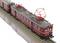 Un train historique rouge foncé, équipé de pantographes, circule sur des rails, vu de dessus et légèrement de côté.