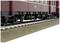 Un wagon rouge sur des rails de chemin de fer. L'accent est mis sur le châssis et les roues. Le train est présenté en vue détaillée.