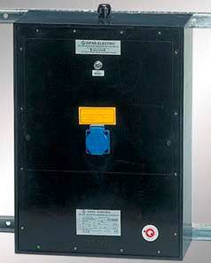 Boîte de distribution électrique montée sur un mur, avec une prise électrique bleue et un étiquetage jaune. En haut est inscrit 'GFPS ELECTRIC'.