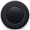 Un haut-parleur rond noir avec un dessus lisse et sensible au toucher, où les symboles plus et moins sont visibles.