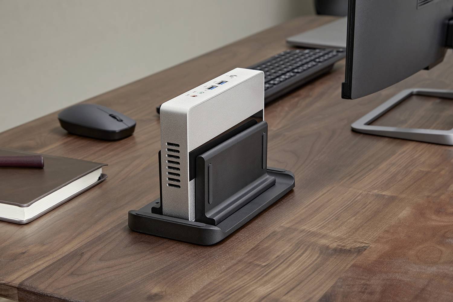 Une station d'accueil avec un appareil connecté est placée sur un bureau à côté du clavier et de la souris.