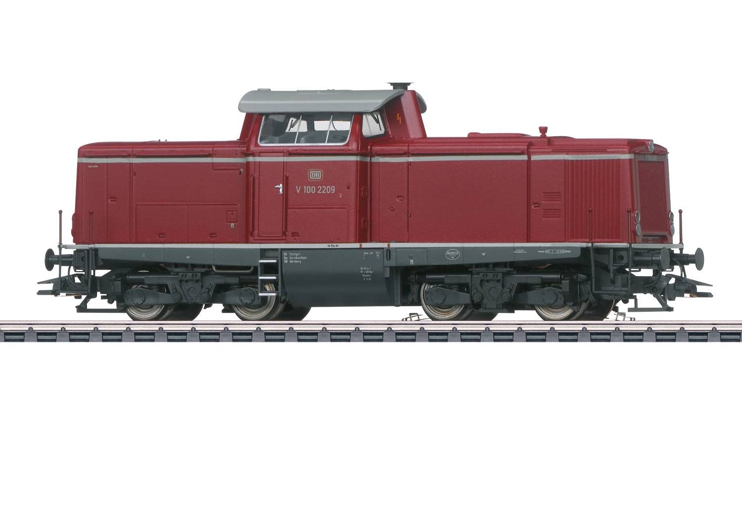 Locomotive diesel rouge sur une voie, vue latérale, avec un toit argenté et des roues noires, immobile.