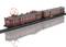 Modèle de train sur rails avec deux wagons, peinture brillante rouge foncé et reproduction détaillée des pantographes sur le toit.