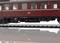 Une voiture de chemin de fer historique rouge de la Deutsche Bahn, de deuxième classe, est stationnée sur des rails. La voiture est richement détaillée.