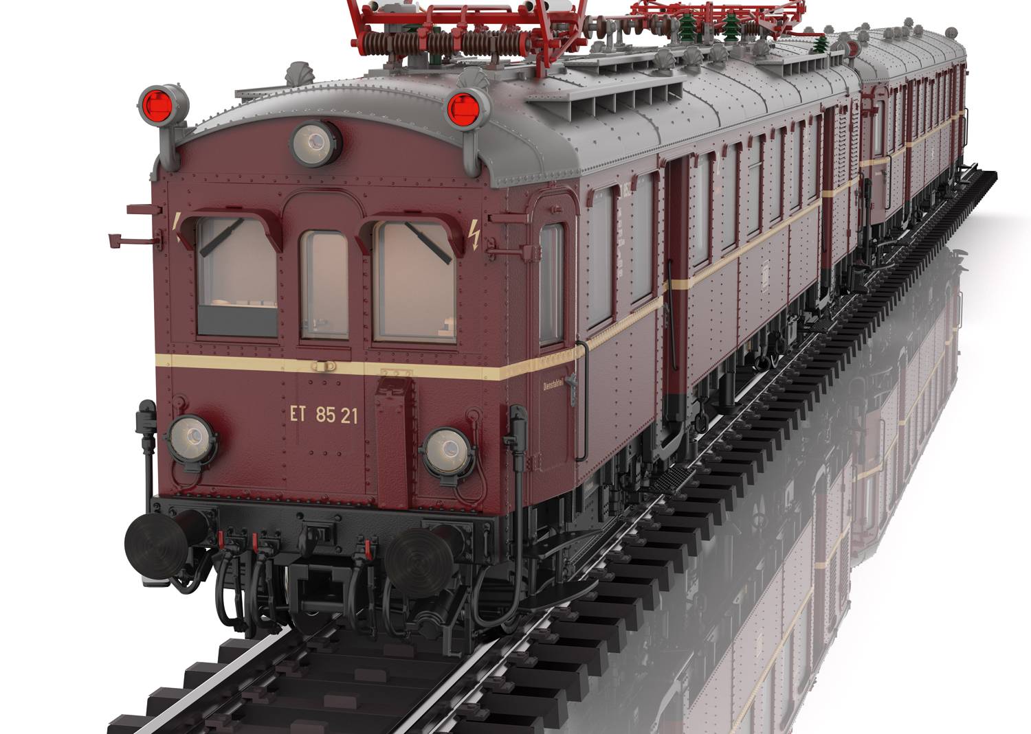 Un autorail marron de la série ET 85 circule sur des rails. L'avant du véhicule avec ses phares et les caténaires sont visibles.
