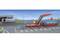 Un paysage de jouet avec une station de chargement rouge et un train de conteneurs bleu. À l'arrière-plan, un bâtiment portant l'inscription « Service & Repair ».