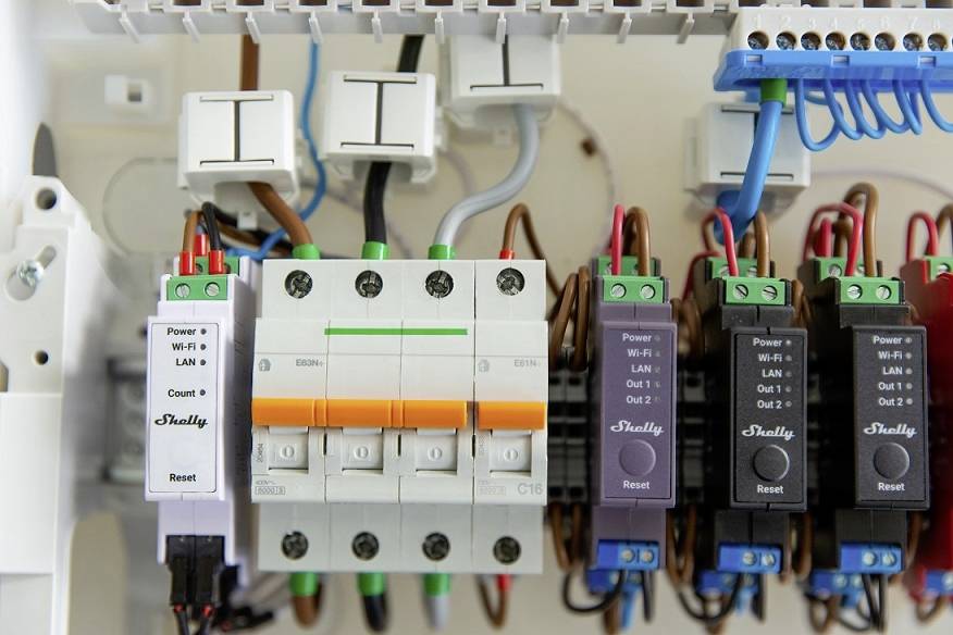 Gros plan d'un boîtier électrique avec plusieurs interrupteurs et câbles. Étiquettes sur les modules : Power, LAN, Reset.