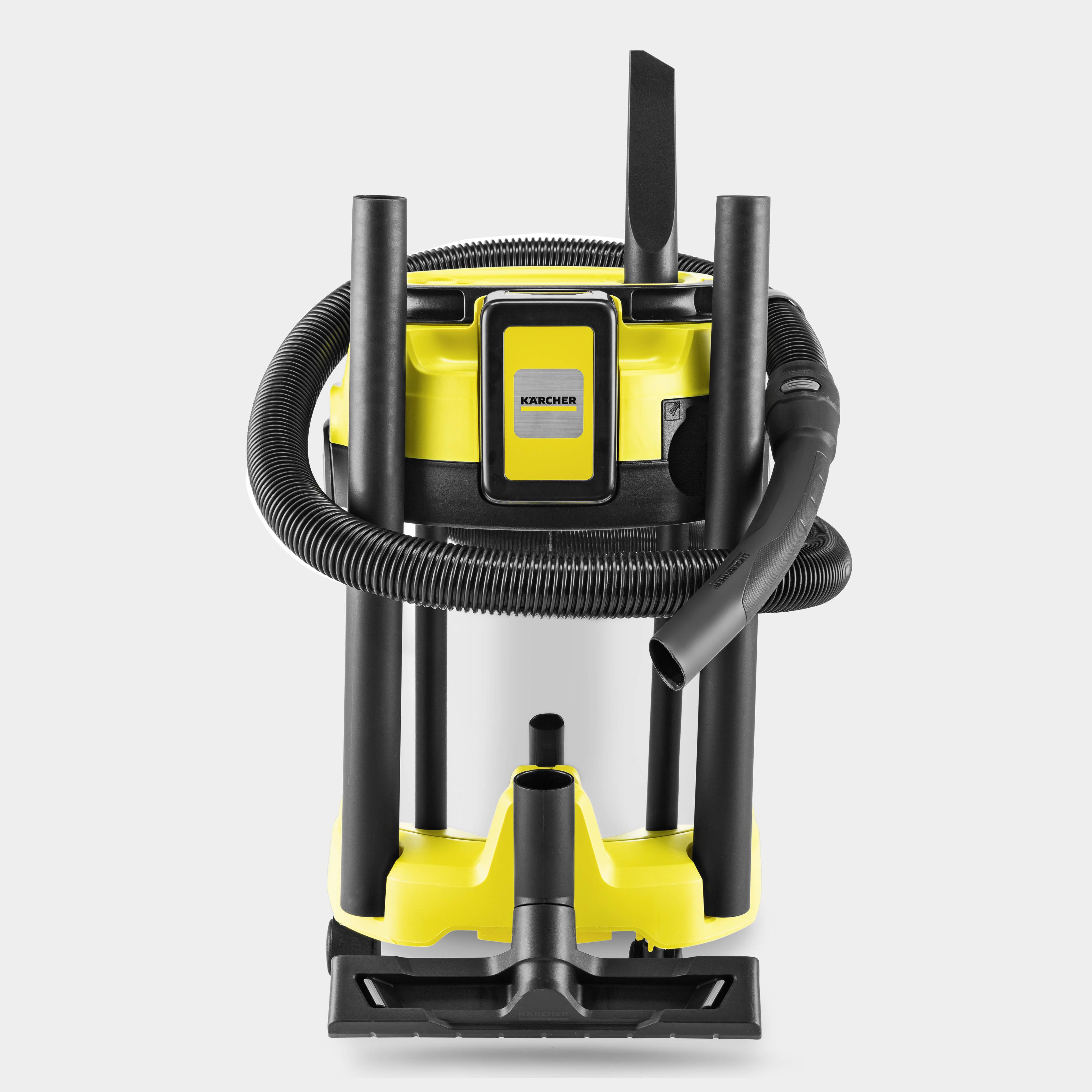 Un aspirateur industriel jaune et noir avec un tuyau raccordé, adapté aux travaux de nettoyage intensifs.