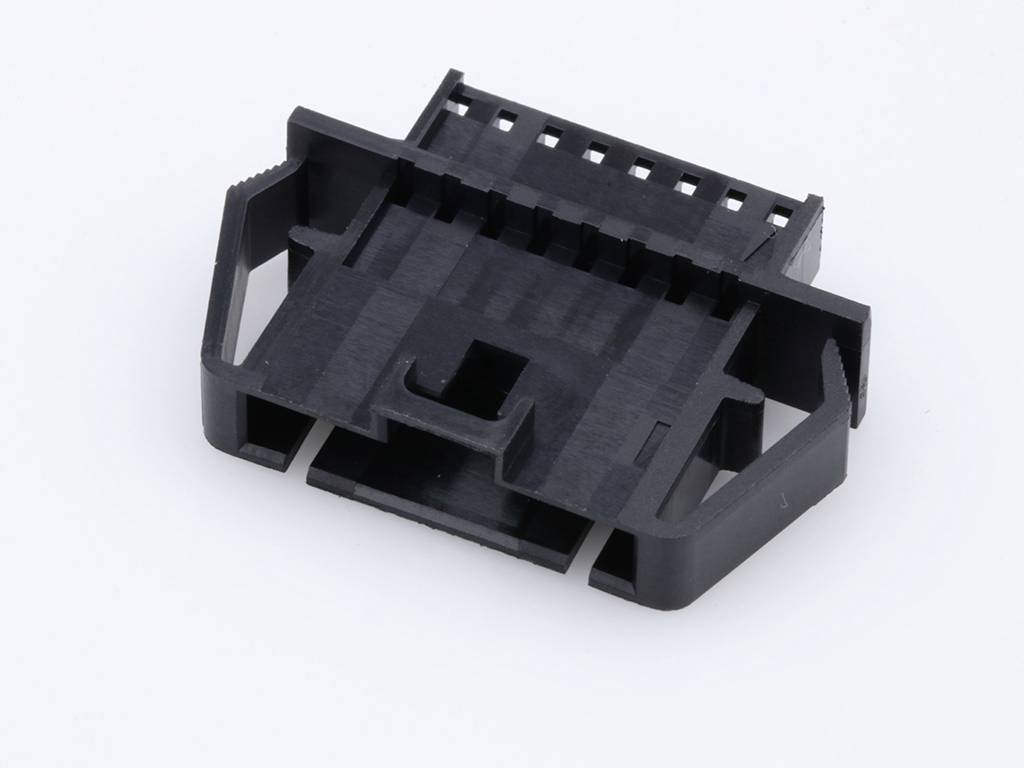 Fiche en plastique noir sur fond blanc, avec plusieurs socles de contact et des clips de fixation latéraux.