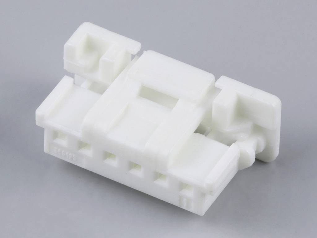 Un connecteur en plastique blanc avec plusieurs emplacements sur un fond gris.