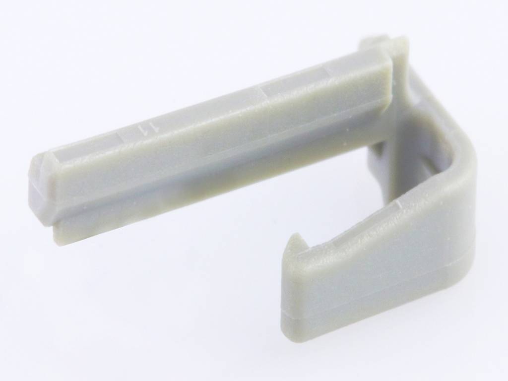 Un clip en plastique gris en forme de L, couramment utilisé pour la fixation des câbles.