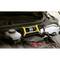 Un chargeur de batterie jaune affiche une tension de 12,8 volts sur son écran. Il est connecté à une batterie de voiture.