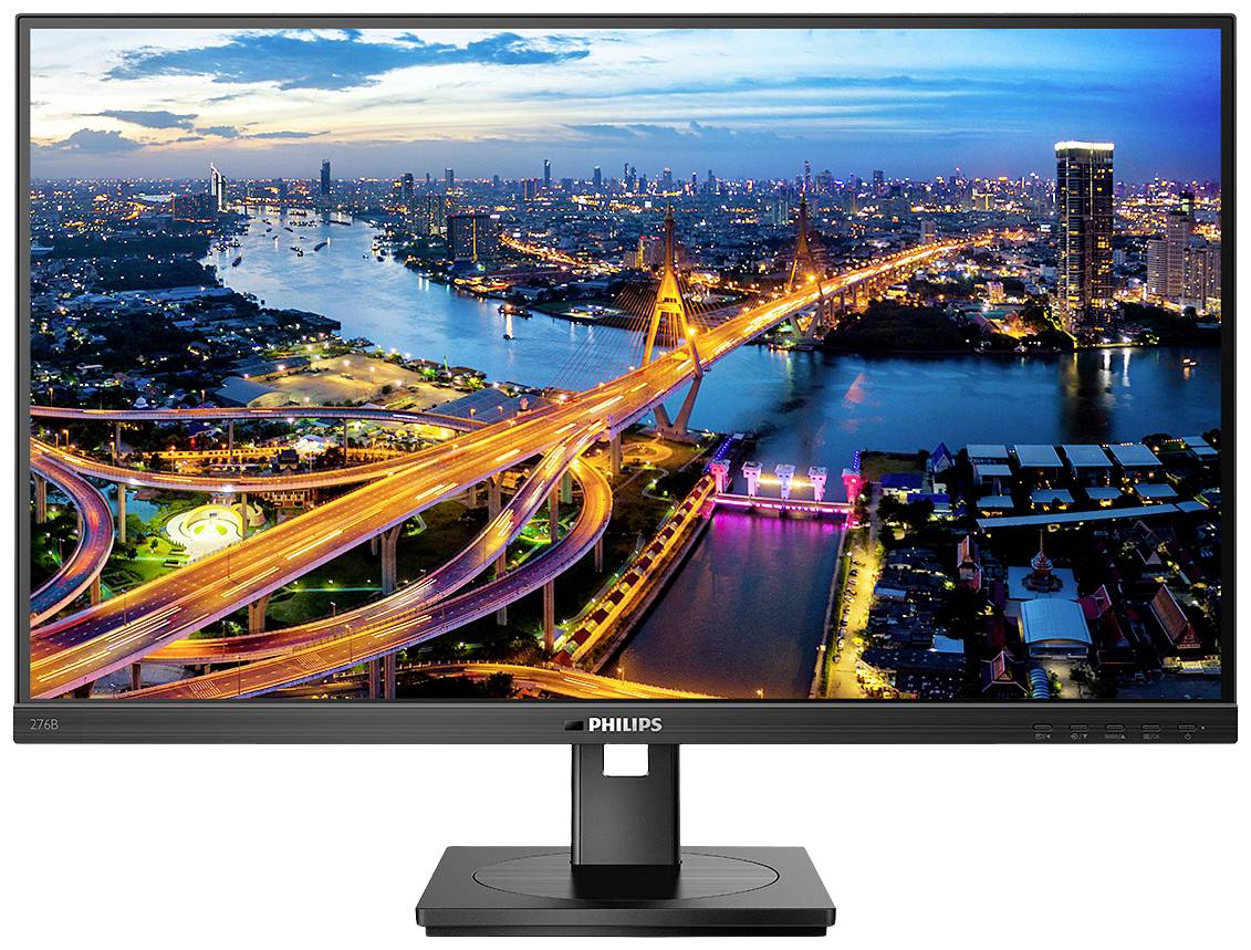 Un moniteur Philips affiche une vue de ville au crépuscule avec des ponts illuminés et des bâtiments le long d'un fleuve en arrière-plan.