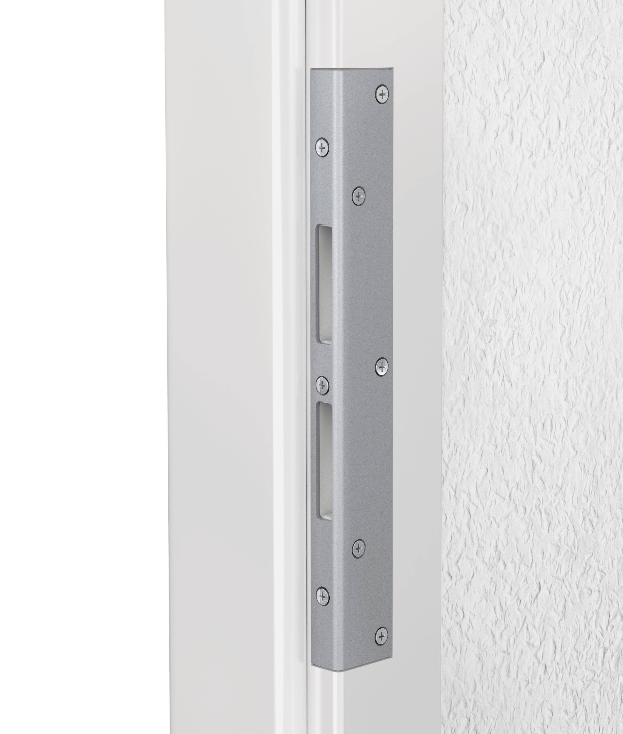 Gros plan sur un mécanisme de charnière métallique sur un encadrement de porte blanc. Le support comporte plusieurs vis de fixation.