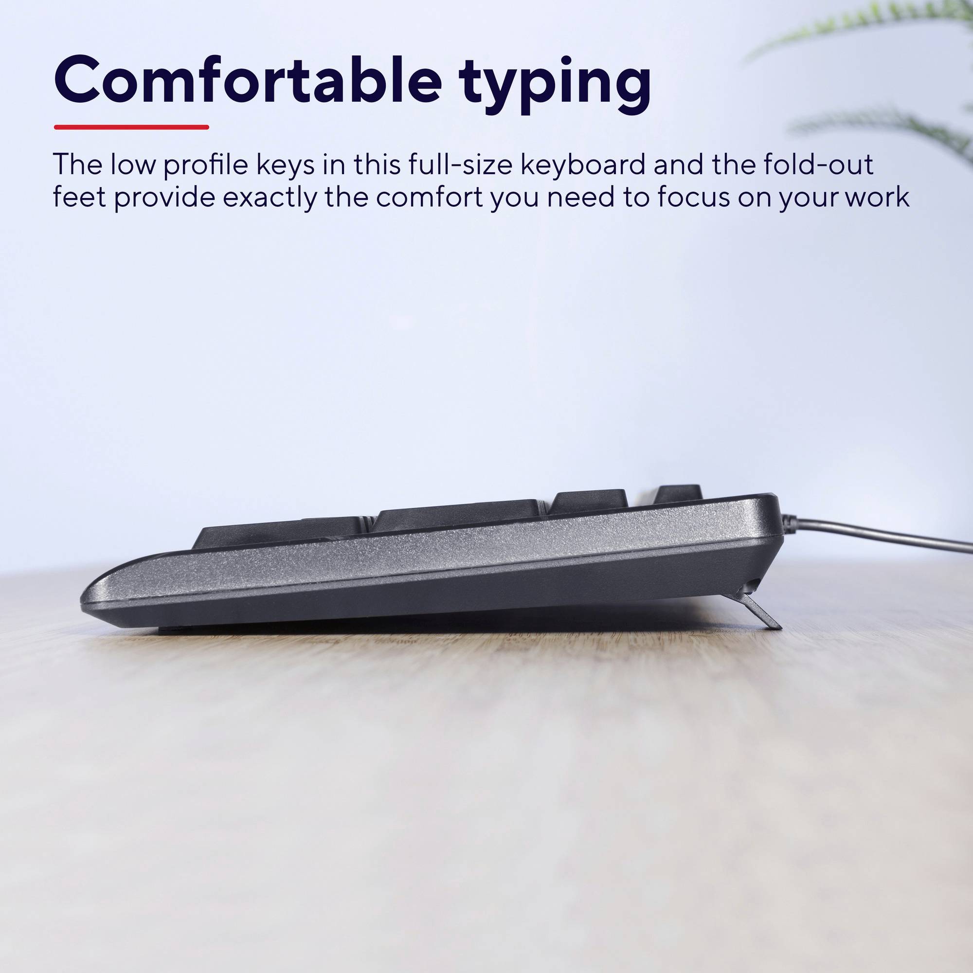 Vue latérale d'un clavier sur un bureau. Le texte au-dessus indique : « Une frappe confortable ». Une plante se trouve en arrière-plan.