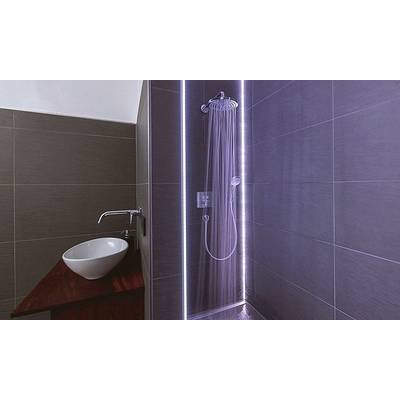Cabine de douche avec eau courante et éclairage LED, à côté d'un lavabo moderne avec un lavabo blanc.