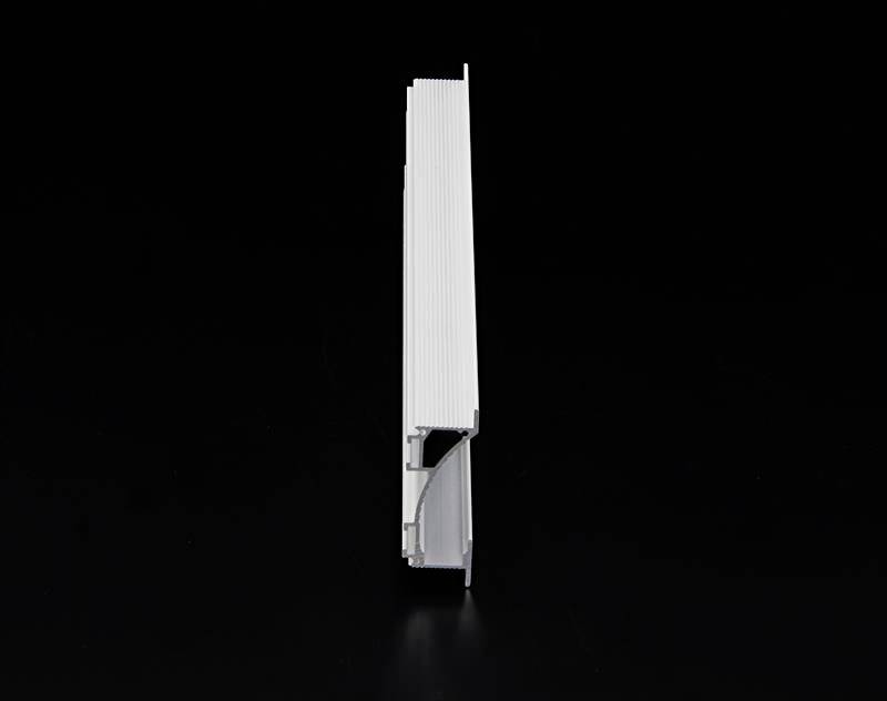 Objet métallique en position verticale devant un fond noir. Il a une forme rectangulaire avec une surface striée.