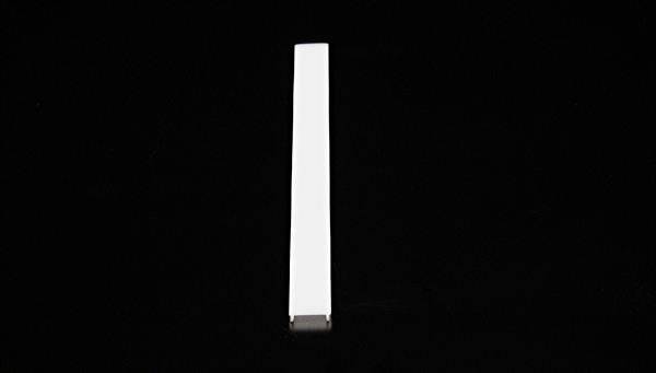 Une longue barre blanche étroite est positionnée verticalement sur un fond noir.