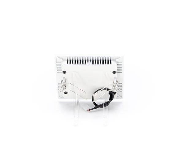 L'image montre l'arrière d'un appareil électronique blanc avec des fentes de ventilation et des connexions de câbles visibles au premier plan.