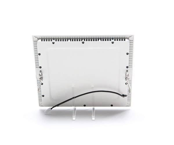 Vue arrière d'un appareil électronique blanc posé sur un support transparent, avec un câble noir et des vis visibles.