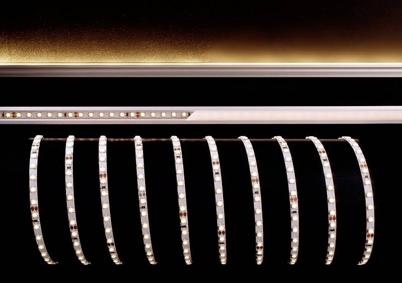 Bande de LED avec lumière blanc chaud dans un environnement sombre, disposée en un arc élégant.