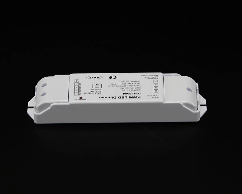 Un variateur LED PWM blanc avec marquage CE est posé sur une surface noire. Le variateur dispose de plusieurs bornes de connexion.
