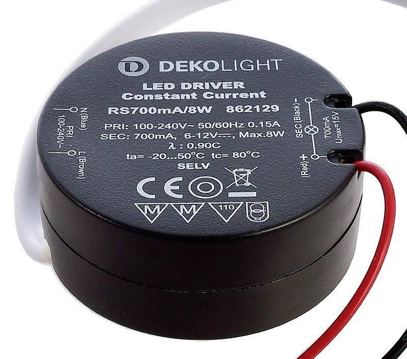 Un driver LED rond portant l'inscription 'DEKOLIGHT LED DRIVER Constant Current'. Les données d'entrée et de sortie sont imprimées dessus.