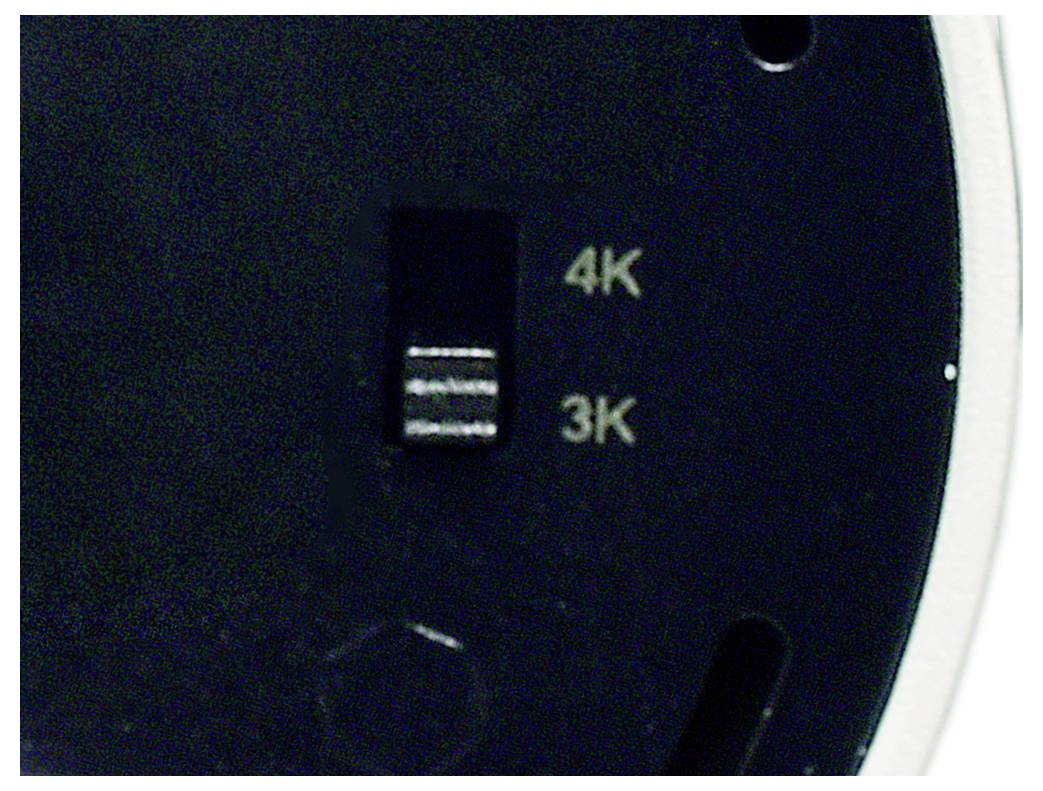 Gros plan sur le panneau de commande d'un appareil avec un petit interrupteur entre les réglages « 4K » et « 3K ».