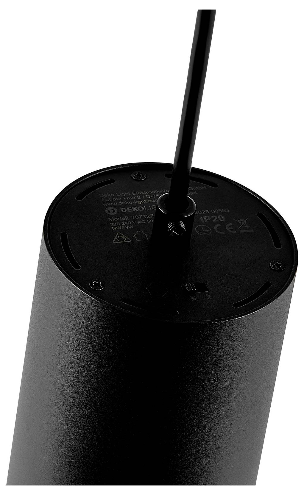 Gros plan d'un appareil électronique cylindrique noir avec un câble entrant par le haut, montrant le panneau supérieur de l'appareil et les marquages réglementaires.