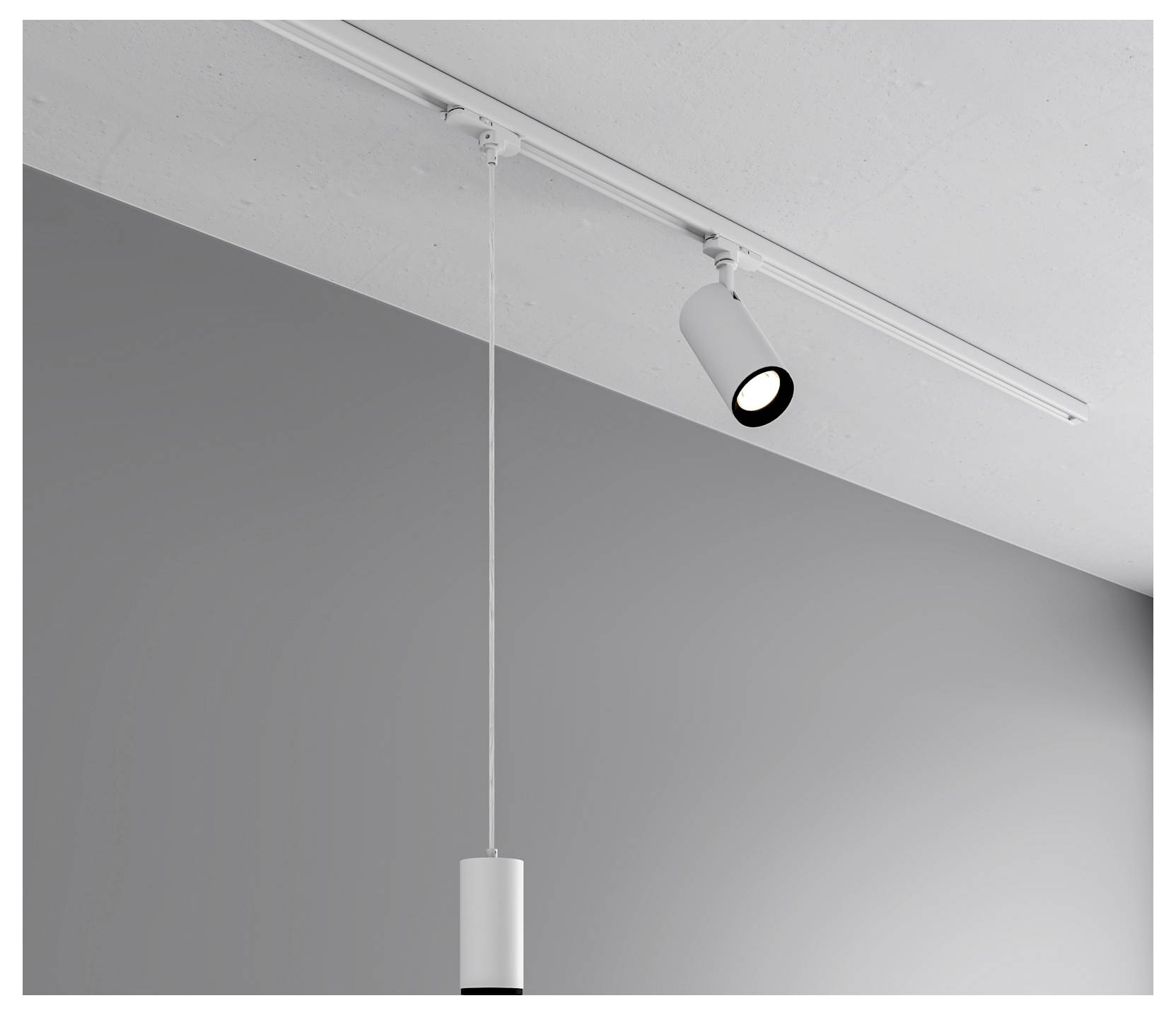 Éclairage sur rail au plafond avec un spot unique et un luminaire suspendu contre un mur gris uni.
