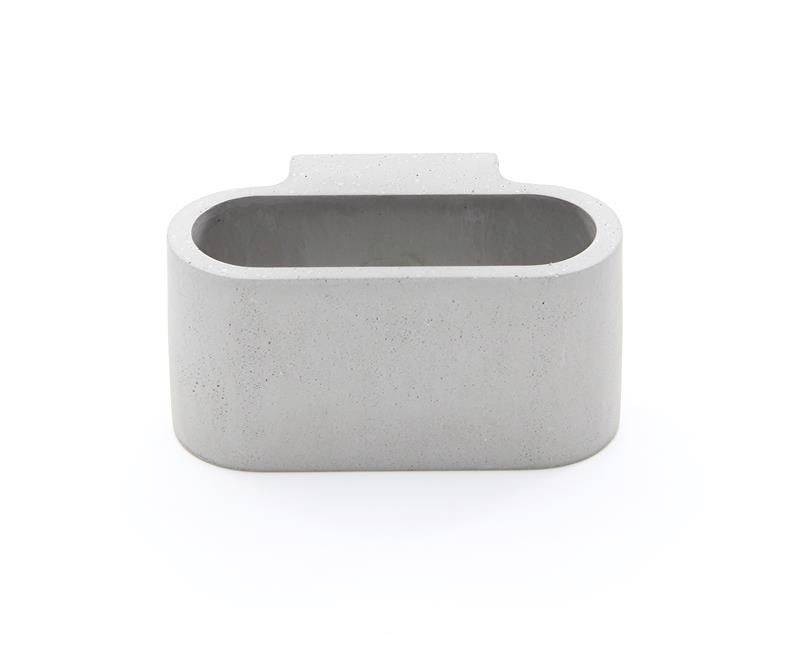 Récipient en béton gris, rectangulaire, aux angles arrondis, avec une ouverture en haut.
