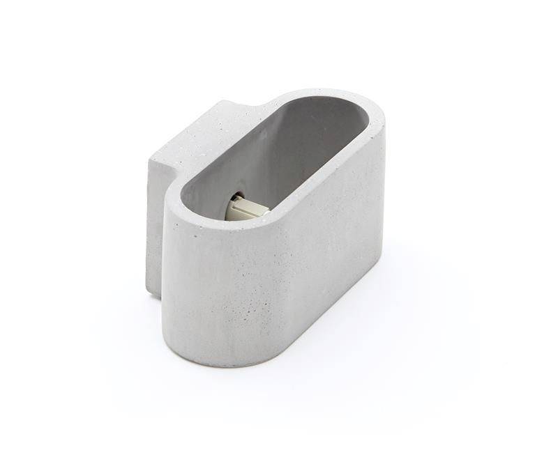 Auge ovale grise en béton avec une section rectangulaire. Contient un élément dissimulé à l'intérieur.