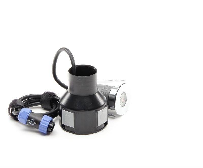 Un adaptateur noir cylindrique avec un câble et une connexion bleue. En arrière-plan, un appareil argenté avec un écran rond.
