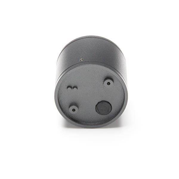 Un objet cylindrique noir avec trois points marqués sur sa surface plane.
