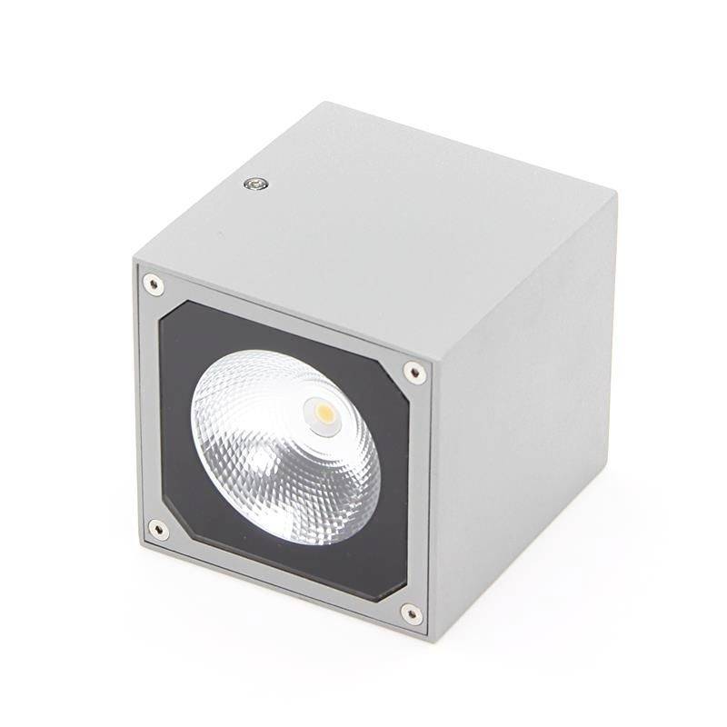 Un luminaire LED carré gris avec un bord noir et un réflecteur central, sur un fond blanc.