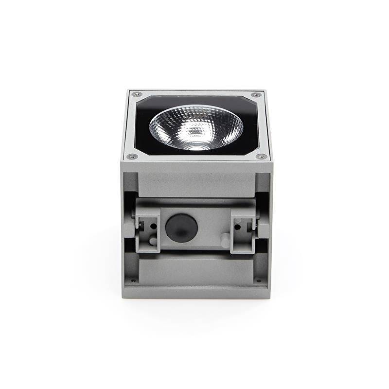 Un luminaire de plafond gris cubique avec un élément LED visible au centre, adapté aux espaces intérieurs modernes.