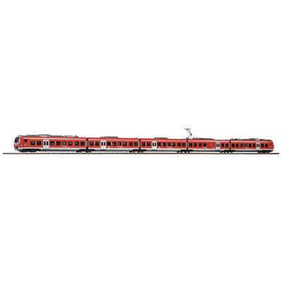 Un train rouge composé de plusieurs wagons circule sur une voie ferrée. Le train comprend trois wagons et est équipé de pantographes pour la traction électrique.