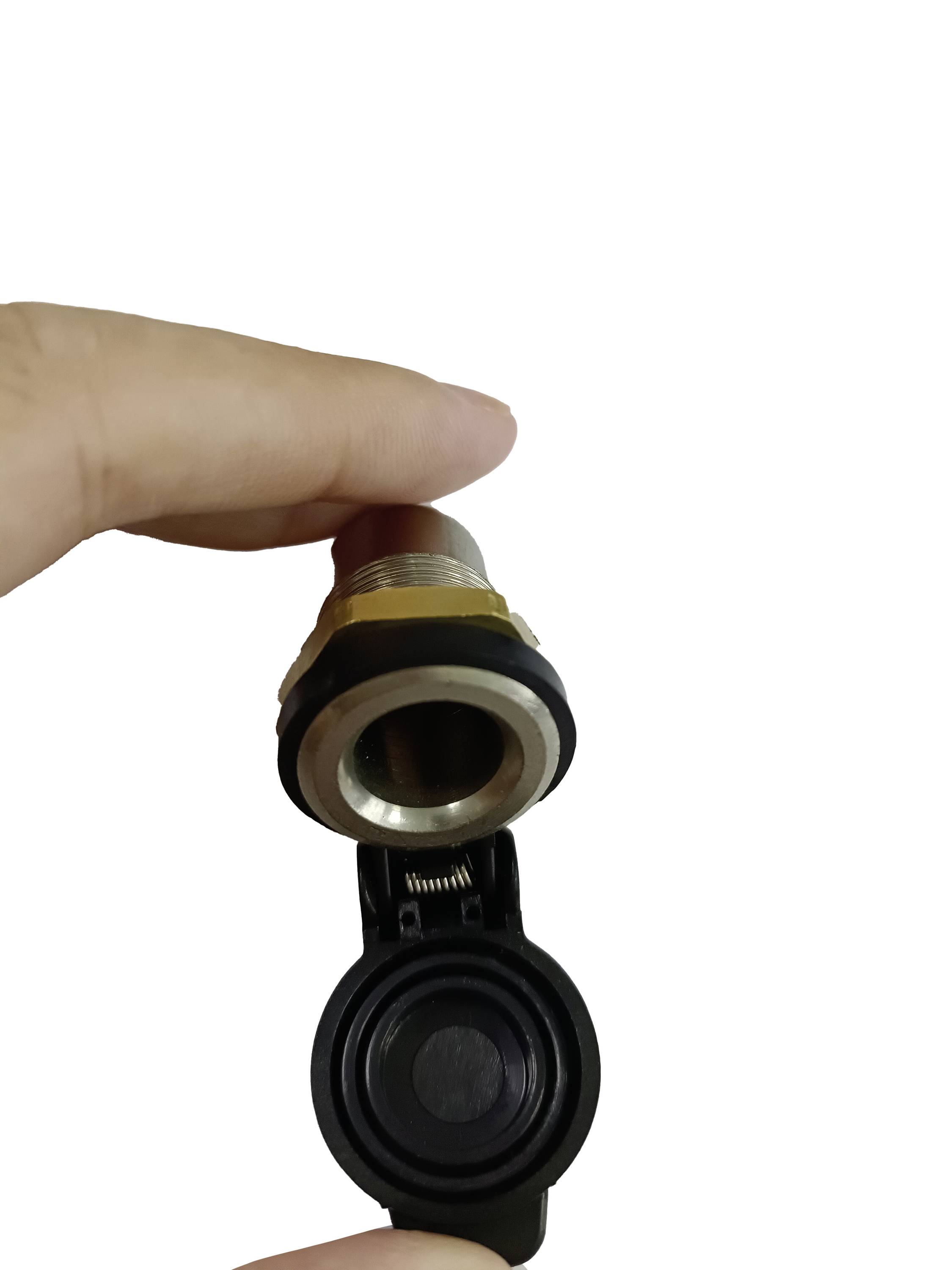 Une main tient une prise électrique en métal avec un couvercle en plastique noir, utilisée pour connecter des câbles.