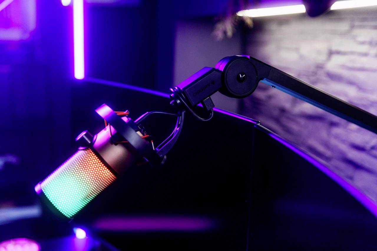 Un microphone avec des lumières colorées sur un bras ajustable dans un environnement moderne faiblement éclairé.