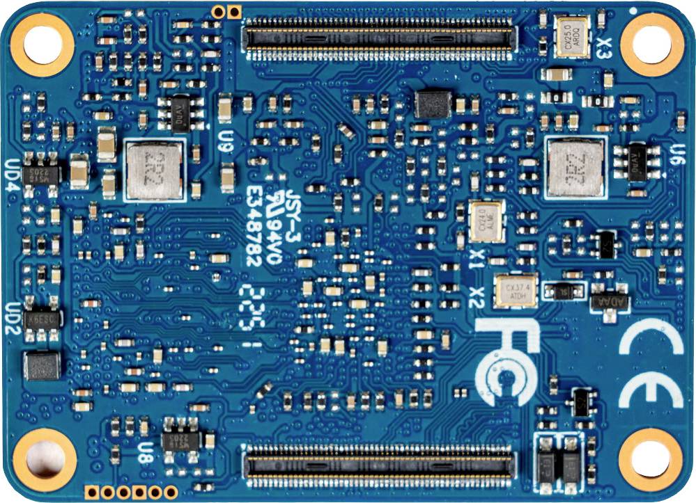 Carte d'ordinateur bleue avec des composants électroniques et des pistes de circuit imprimé. Marquages CE et FCC dans le coin inférieur droit.
