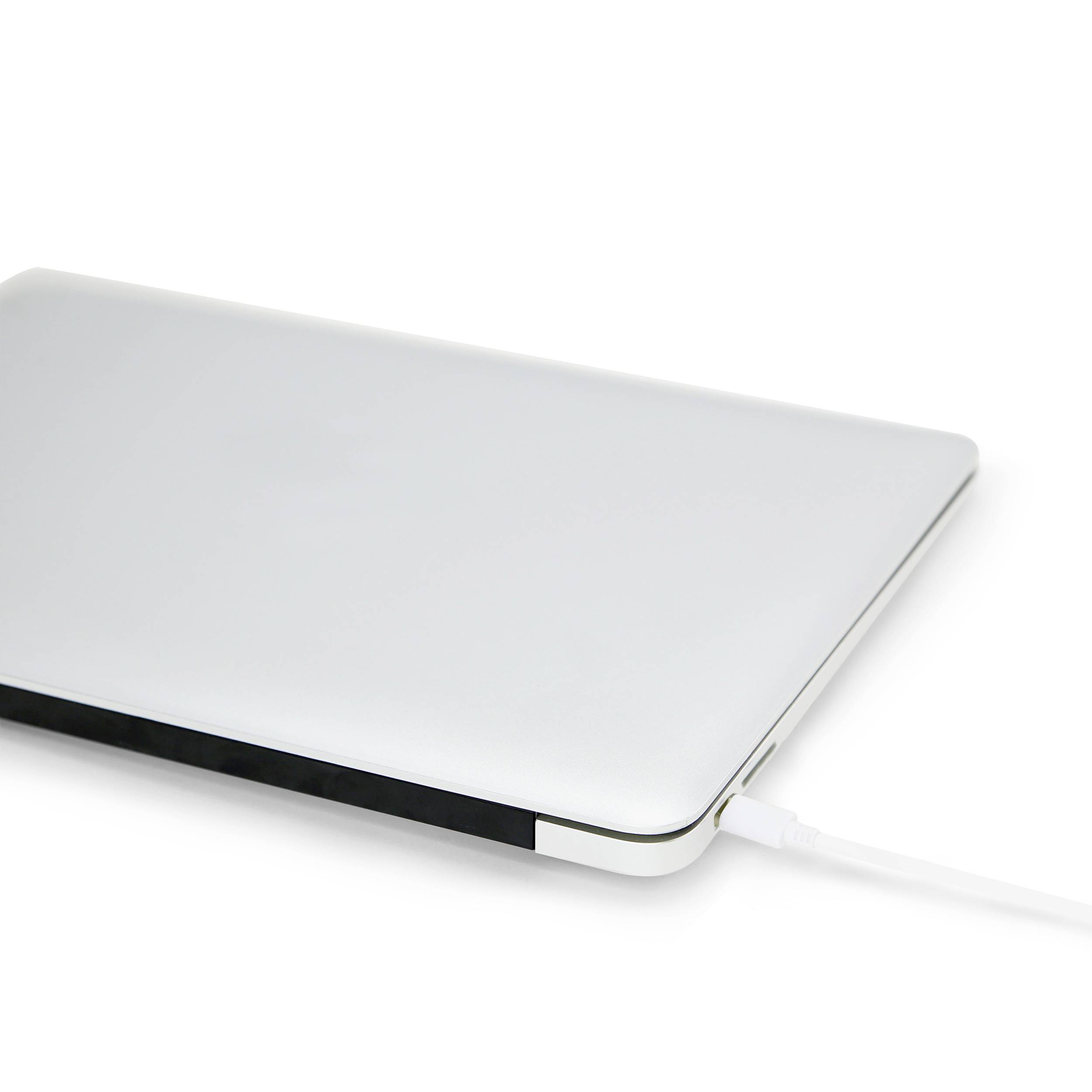 Un ordinateur portable fermé avec un boîtier argenté est branché à un câble blanc qui semble probablement être en train de le charger.