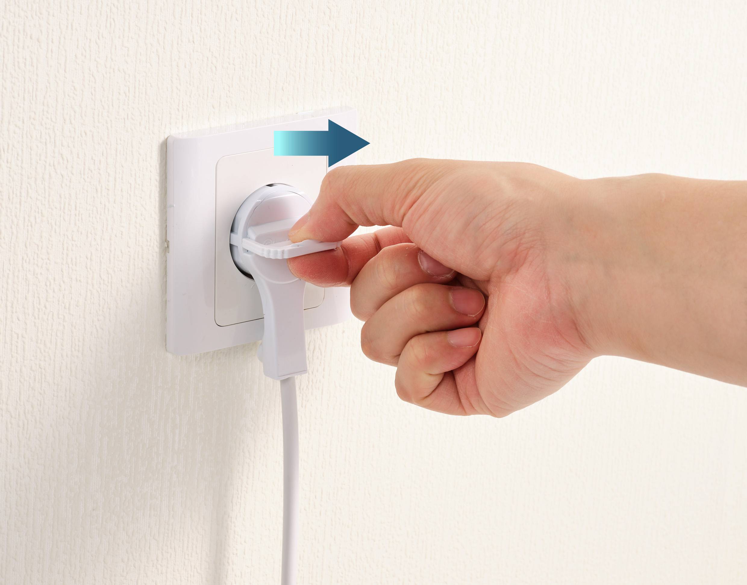 Une main retire une fiche de la prise électrique. Une flèche bleue indique la direction du retrait.