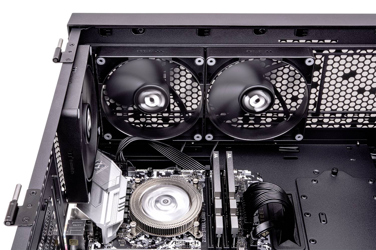 L'image montre l'intérieur d'un boîtier d'ordinateur avec des ventilateurs installés, un dissipateur thermique et des câbles visibles sur une carte mère.