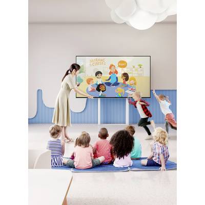 Une enseignante montre aux enfants un dessin sur l'écran intitulé 'Cercle du matin'. Les enfants écoutent attentivement.