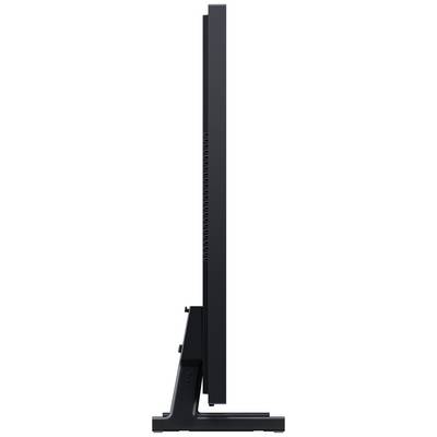 Vue latérale d'un écran d'ordinateur très fin, noir, monté sur un support qui met en valeur sa silhouette élancée.