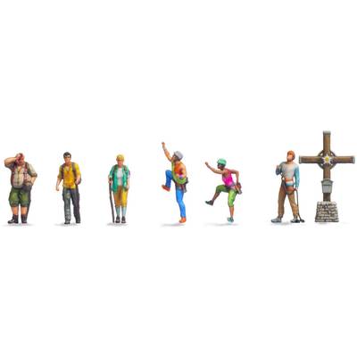 Six figurines miniatures en randonnée, avec différentes poses et équipements. À droite, une croix en bois est dressée sur un socle en pierre.